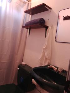 科万Cobán room的浴室设有黑色的卫生间和水槽。