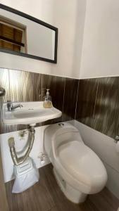 une salle de bain avec des toilettes blanches et un lavabo dans l'établissement Apartaestudios tipo loft Prado Station, à Medellín 10 autres photos