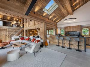 una sala de estar con un sofá y una mesa en Chalet 5⭐ à Méribel avec Spa, Salle de Sport, Proche des Pistes et Commerces - FR-1-566-62, en Les Allues