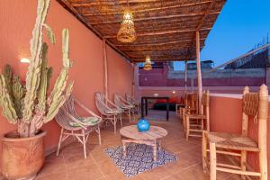 a patio with chairs and a table and a cactus at Riad GUENAOUA Jacuzzi & Rooftop in Marrakesh