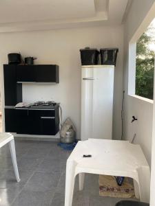 a kitchen with a white stove and a white table at Chalé Velho Chico in Canindé de São Francisco