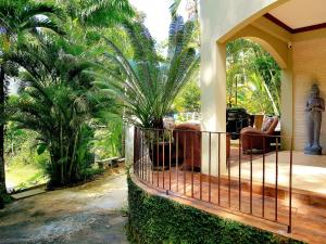a porch of a house with a fence and palm trees at Casa Tucuche in Las Cuevas