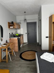 a room with a bed and a kitchen with a table at Thea comfy living in Nea Vrasna