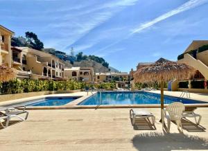 アルテアにあるLUXURY ALTEA Campomanesの建物の隣にプール(椅子、パラソル付)