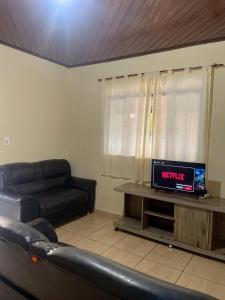 a living room with a couch and a television at Conforto no Centro da Cidade in Alta Floresta