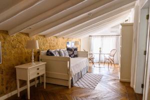 a bedroom with a bed and a table at TW Guaimbê Exclusive Suítes in Ilhabela