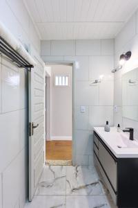 Baño blanco con lavabo y puerta en Casa Miranda no Centro Histórico, en Paraty