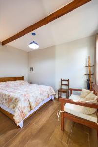 Un dormitorio con una cama, una mesa y una silla. en Casa Miranda no Centro Histórico, en Paraty