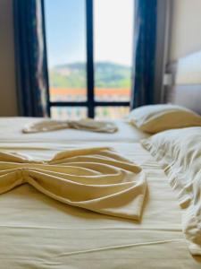 two beds with white sheets and a window at Rooms Ibrocevic in Ulcinj