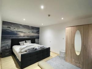 a bedroom with a large bed and a large mirror at The Cottages - Pet Friendly in Meißendorf