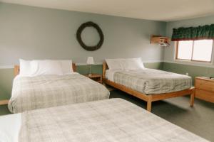 a bedroom with two beds and a mirror on the wall at Adventure Inn in Ely +39 photos