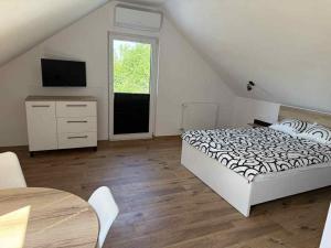 a bedroom with a bed and a television and a table at Pokoje Gościnne Nad Jeziorem in Rajgród