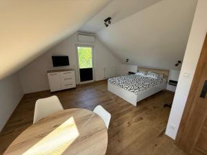 a bedroom with a bed and a table in a attic at Pokoje Gościnne Nad Jeziorem in Rajgród