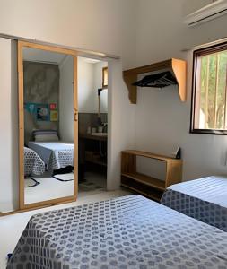 a bedroom with two beds and a mirror at Casa LARVC no coração de Pirenópolis! in Pirenópolis