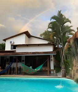a rainbow over a house with a swimming pool at Casa LARVC no coração de Pirenópolis! in Pirenópolis
