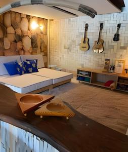 a bedroom with a bed and guitars on the wall at Casa LARVC no coração de Pirenópolis! in Pirenópolis