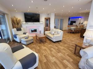a living room with white furniture and a fireplace at Top Of The Lane Luxury Holiday Apartment in Benllech