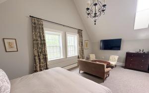 a bedroom with a bed and a chair and a window at Grafton Village Inn in Grafton