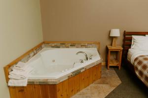 a bath tub in a room next to a bed at Adventure Inn in Ely