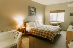 a bedroom with a bed and a bath tub at Adventure Inn in Ely