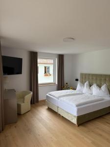 a bedroom with a large white bed and a window at Seehotel Lilly in Strobl