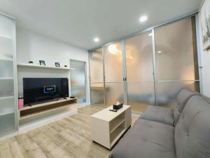 salon z kanapą i telewizorem z płaskim ekranem w obiekcie Modern Cozy Suvarnabhumi w mieście Ban Khlong Prawet