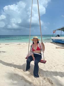 uma mulher sentada num baloiço na praia em Discovery Gunayar em Cayos Los Grullos mais 8 fotografias