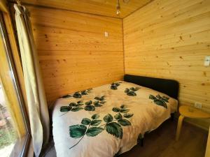 a bedroom with a bed in a wooden cabin at Cabana Padurea Cerbilor in Moara de Pădure
