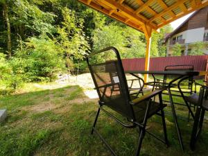 een tafel en stoelen onder een prieel bij Cabana Padurea Cerbilor in Moara de Pădure +5 foto's