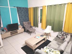a living room with a couch and a tv at Rayanil Residence in Mayotte