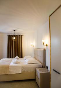 a bedroom with a white bed and a mirror at Villa Terra Promessa in Ulcinj