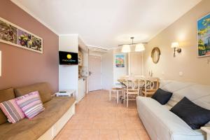 ein Wohnzimmer mit Sofa und Tisch in der Unterkunft Résidence les Calanques des Issambres - maeva Home - Studio 4 Personnes - Sélection MAE-8566 in Les Issambres