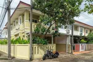 a motorcycle parked in front of a yellow house at OldTown Home Phuket 3min walk Central Festival in Ban Rangeng