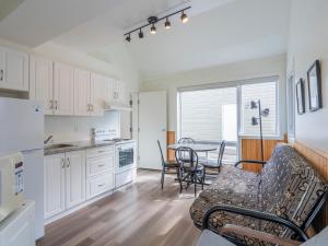 a kitchen and living room with a table and chairs at Studios d'hébergement du Domaine in Saint-Irénée +17 photos