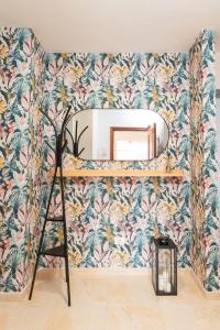 a mirror on a wall with a tropical wallpaper at Brisas de Güimar in Santa Cruz de Tenerife