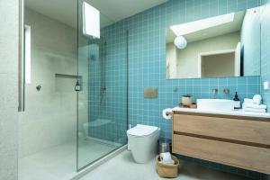Un baño con ducha, inodoro y lavabo. en Modern Mid-Century Retreat, en Dunedin 32 fotos más