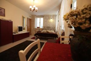 ein Wohnzimmer mit einem Bett und einem TV in der Unterkunft Tragurium & Salona Apartments in Trogir