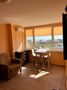 a living room with a table and chairs and a couch at Променад Бугаз in Zatoka