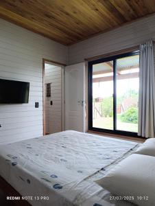 une chambre avec un grand lit et une grande fenêtre dans l'établissement Minicasa Ensueño, à Colonia Hocker