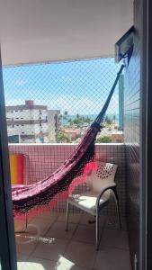 a hammock on top of a balcony with a window at Apartamento pé na areia - João Pessoa -Paraíba in João Pessoa