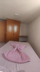 a pink robe laying on top of a bed at Apartamento pé na areia - João Pessoa -Paraíba in João Pessoa