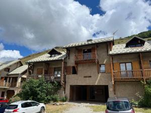 a large house with cars parked in front of it at Les Soleils de la Meije in La Grave