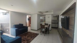 a living room with a blue couch and a table at Apartamento pé na areia - João Pessoa -Paraíba in João Pessoa