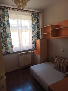a small bedroom with a bed and a window at Apartament u Basi in Sanok