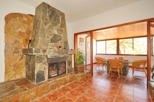 a living room with a large stone fireplace at VV Complejo Vacacional VillaMaría in Los Llanos de Aridane