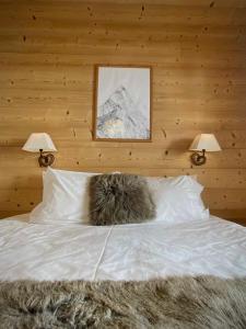 a cat sleeping on a bed with two lamps at Hotel La Crémaillère in Le Grand-Bornand