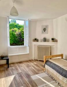 a bedroom with a bed and a window at Maison spacieuse et paisible à La Trimouille in La Trimouille