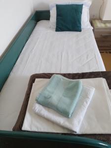 a bed with towels on top of it at Nada Apartman in Lastva