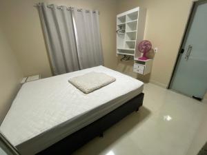 una camera da letto con un letto bianco con uno specchio di Casa de praia toda mobiliada na primeira quadra da ilha de Guriri São Mateus ES a São Mateus
