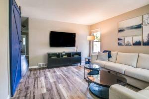 4Bedrooms 2 and 1 Half Bath Home for 9 Kid and Game Ready في غرين باي: غرفة معيشة مع أريكة وتلفزيون بشاشة مسطحة